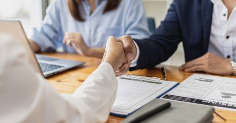 Managers en sollicitanten schudden elkaar de hand na het sollicitatiegesprek